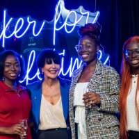 Three girls hold their champagne flutes and take a picture with President Mantella.